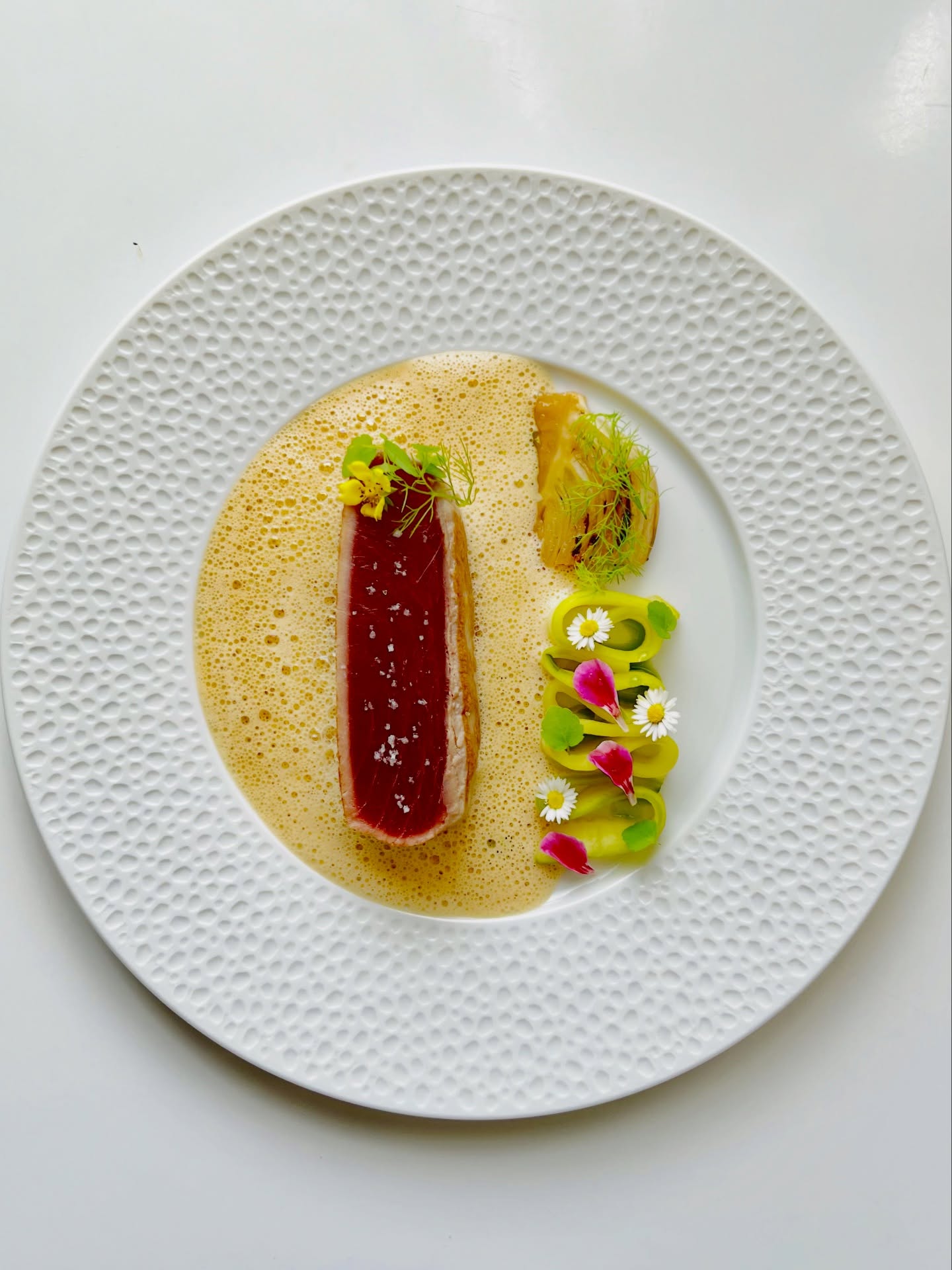 Découvrez notre Chef
Chef Htun Htun
« Mes plats sont mes histoires. »
L'’éritage birman, exprimé à travers la gastronomie française.
Feu • Précision • Mémoire
Chaque chef possède une signature. Celle du Chef Htun Htun est avant tout une histoire.
Originaire du Myanmar (Birmanie), le Chef Htun Htun consacre depuis plus de quinze ans sa vie à la haute gastronomie. Son parcours l'’ conduit dans des restaurants prestigieux et des hôtels de luxe à travers plusieurs pays, où il a forgé une cuisine exigeante, élégante et profondément personnelle.
Reconnu parmi les chefs les plus talentueux de son pays, il développe aujourd'’ui en France une identité culinaire unique, où la rigueur de la gastronomie française rencontre la richesse des saveurs birmanes. Plus qu'’ne simple fusion, sa cuisine est un dialogue entre deux cultures, où chaque assiette raconte un souvenir, une émotion ou un voyage.
Pour le Chef Htun Htun, cuisiner, c'’st transmettre une histoire. Une enfance au bord des rivières du Myanmar, les parfums des marchés, les recettes familiales, les rencontres et les expériences acquises au fil des années prennent vie dans chacune de ses créations.
Son travail s'’ppuie sur le respect absolu du produit, la saisonnalité et la précision du geste. Chaque menu est imaginé avec exigence, afin d'’ffrir un équilibre parfait entre technique, créativité et émotion.
Aujourd'’ui, en tant que Chef de Cuisine du restaurant Le 10 Vins, il signe une cuisine gastronomique contemporaine, délicate et sincère. En harmonie avec la philosophie de la maison et les accords mets et vins imaginés par Julien Terrier, il invite chaque convive à vivre une véritable expérience sensorielle.
Car pour lui, un grand plat ne se résume pas à une recette.
C'’st une émotion, un souvenir… une histoire que l'’n partage autour d’une table.
.
#chanteloupenbrie #chef #gastronomiefrancaise #parisrestaurant #luxurydining